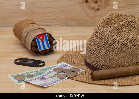 La Siesta - sigari, cappello di paglia e banconote cubano su un tavolo di legno Foto Stock