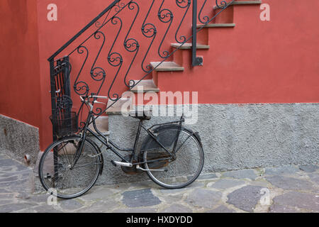 Moto parcheggiata vicino a scale di casa a Monterosso, Italia Foto Stock