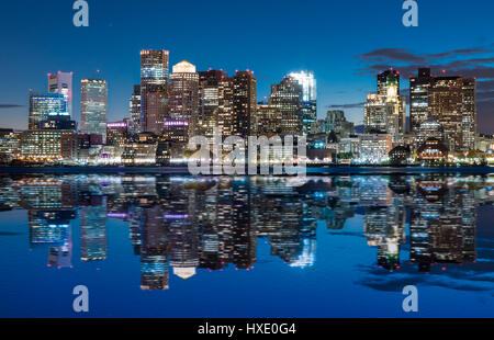 Skyline di Boston al tramonto da attraverso il porto. Foto Stock