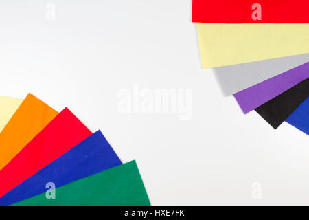 Selezione di feltro colorato fogli disposti come telaio di frontiera su sfondo bianco. Vista superiore Foto Stock