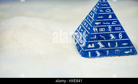 Abstract piramide blu con hieroglyph stare sulla sabbia Foto Stock