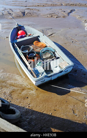 Piccola barca da pesca con attrezzature spiaggiata a bassa marea sulla Costa North Norfolk a Brancaster Staithe, Norfolk, Inghilterra, Regno Unito. Foto Stock