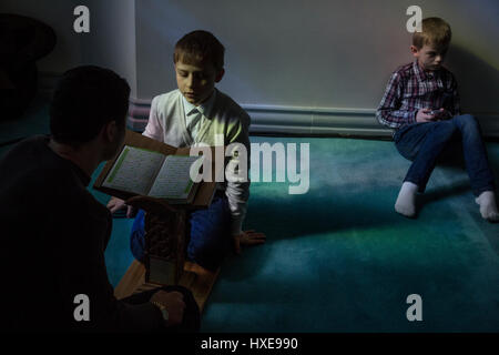 Un membro dei figli il concorso del Corano lettori si sta preparando per la concorrenza nella hall di Mosca moschea cattedrale Foto Stock