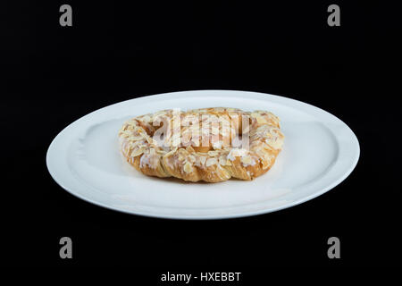 Bella tradizionale europea Pretzel dolci (tedesco Bretzel, Brezl, Breze) su un piatto bianco con sfondo nero Foto Stock