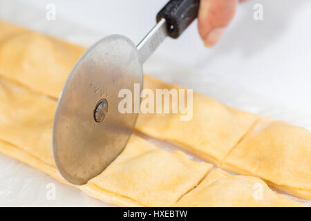 Ravioli Preparazione : tagliare i ravioli ripieni di strisce Foto Stock