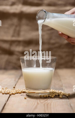 Latte di soia o latte di soia e semi di soia sul tavolo di legno. Foto Stock