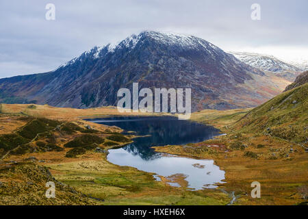 Pen yr Ole Wen mountain riflessa in Llyn Idwal lago con nuvoloso cielo grigio in inverno. Cwm Idwal Ogwen Snowdonia National Park (Eryri) Wales UK Foto Stock