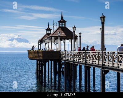 Vista sul molo verso il vulcano Osorno, turisti sul molo di fotografare, villaggio Frutilliar, al lago Llanquihue, chilenean Lake District, Chi Foto Stock