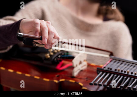 Donna riproduzione di un antico borgo medioevale di strumento musicale moderno, la ricostruzione di un antico nyckelharpa, spesso utilizzato in folk o barocco concerti musicali Foto Stock