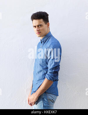 Ritratto di un bel giovane uomo in denim maglietta blu staring Foto Stock