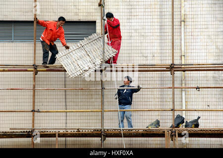 Lavoratori su una costruzione di bambù in Cina a Shanghai. Bambù sono molto veloci la coltivazione di piante e di avere una maggiore resistenza alla compressione di legno che è w Foto Stock