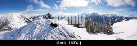 Fantastico inverno alpino wonderland con vista panoramica dalla cima di una montagna innevata incandescente dalla luce del sole. Triebenfeldkogel, Steiermark, Austria. Foto Stock