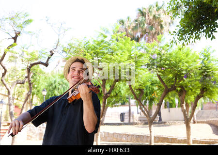 Ritratto di un uomo sorridente suona il violino al di fuori Foto Stock