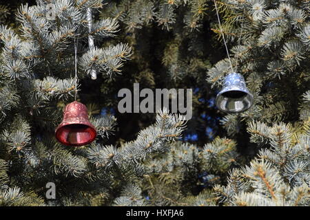 Decorazioni Anno nuovo albero. Tinsel e giocattoli, le sfere e le altre decorazioni di Natale sulla struttura ad albero di Natale in piedi in aria aperta. Foto Stock