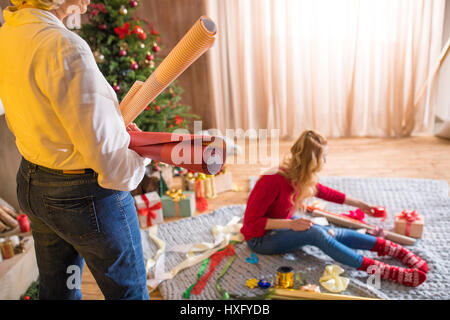 Madre e figlia con rotoli di carta di avvolgimento e scompattato i regali di natale Foto Stock