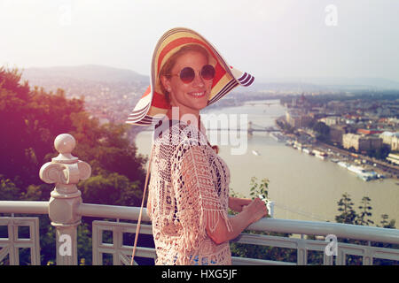 Giovane donna in hat godendosi il panorama di Budapest in stile retrò Foto Stock