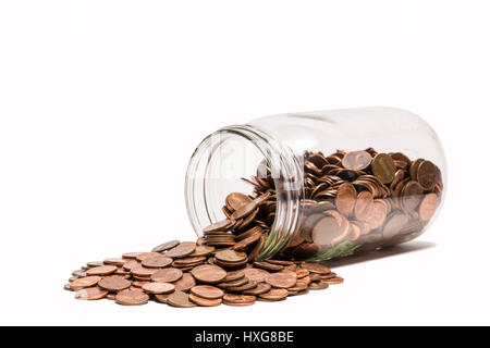 Eventuali fuoriuscite di Penny Jar - un penny jar di lato con pochi spiccioli fuoriuscita. Foto Stock