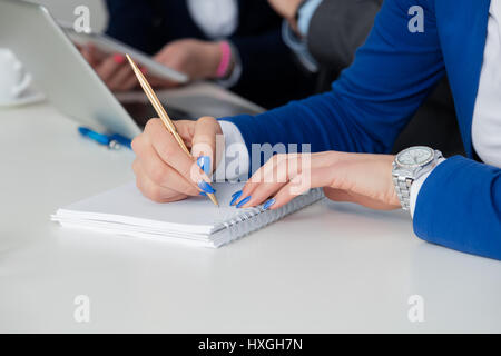 Stretta di mano femminile prendendo appunti su una riunione di affari Foto Stock