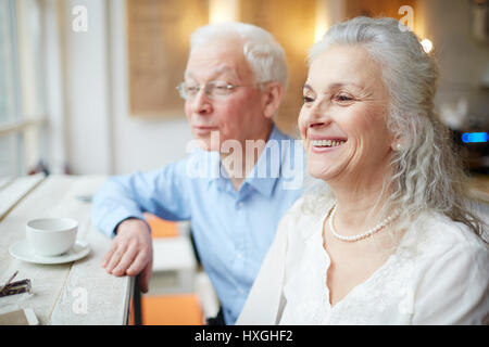 Smiley grey-haired ridere femmina con suo marito vicino Foto Stock