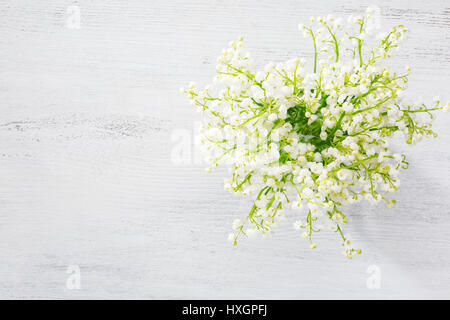 Bouquet di mughetti su sfondo di legno. Foto Stock