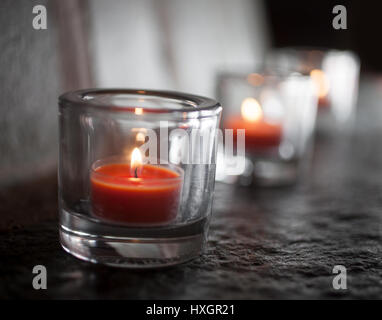 Tre tealight bruciare e incandescente al buio Foto Stock