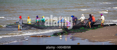 I membri di un filippino villaggio di pescatori haul nel loro seine net a Baybay Beach, Roxas City, Capiz, Panay Island, Filippine Foto Stock
