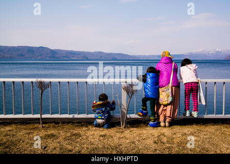 Una famiglia guardando fuori la toya lago vulcanico Hokaido Giappone Foto Stock
