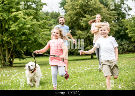 Ragazzo e una ragazza con i genitori come famiglia nella natura divertendosi Foto Stock