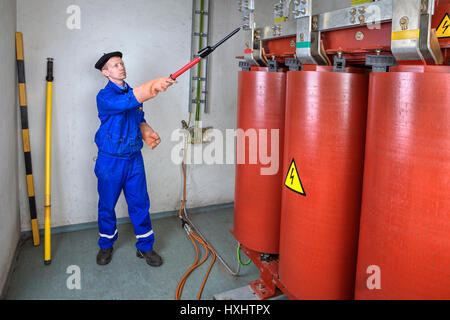 Alta tensione del rivelatore, Elettricista Ingegnere elettrico utilizzando tester ad alta tensione stick per la sicurezza. Foto Stock