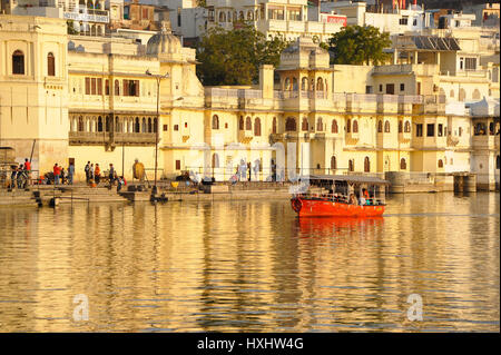 Una barca che porta i visitatori su Udaipur il Lago Pichola, vista palazzo di città come sfondo Foto Stock