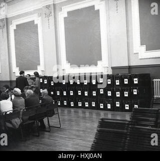 Anni sessanta, storico, line-up di metallo urne di voto in sala di conteggio, Aylesbury, Inghilterra. Foto Stock