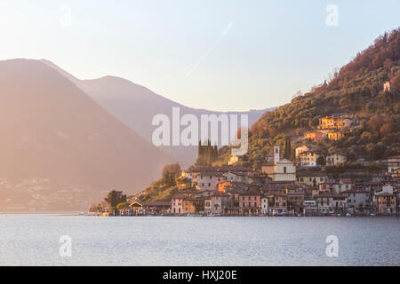 Il comune di Peschiera Maraglio durante un tramonto in inverno, provincia di Brescia, Lago d'Iseo, Lombardia, Italia. Foto Stock