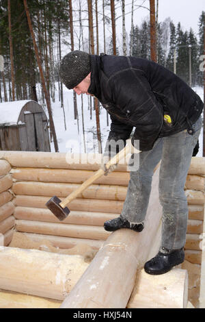 Regione di Leningrado, Russia - 2 Febbraio 2010: tuttofare si allinea una parete con una mazza Foto Stock