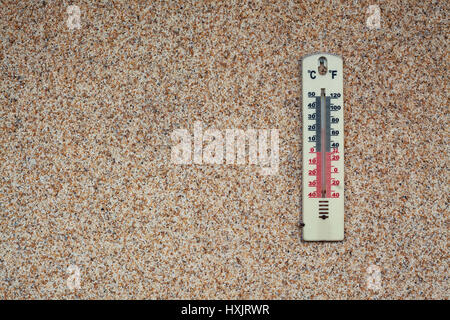 Dettagli di un termometro sulla parete marrone, che mostra la temperatura in gradi Celsius e gradi Kelvin. Foto Stock