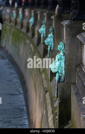Decorativi anelli di ormeggio in forma di Lions Head lungo gli argini del fiume Thames, London, England, Regno Unito. Agiscono come marcatori di inondazione. Foto Stock