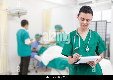 L'infermiera scrivendo un record medici in sala operatoria Foto Stock
