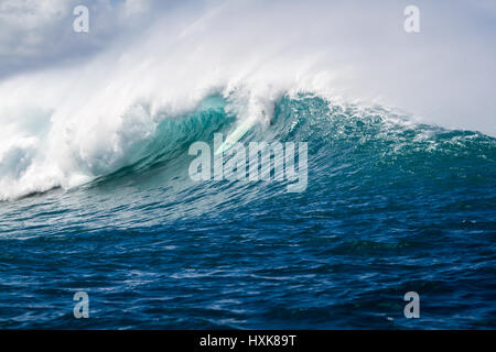 Un surfista salviette fuori su un grande oceano onda su un outer reef break di surf sulla North Shore di Oahu Hawaii Foto Stock