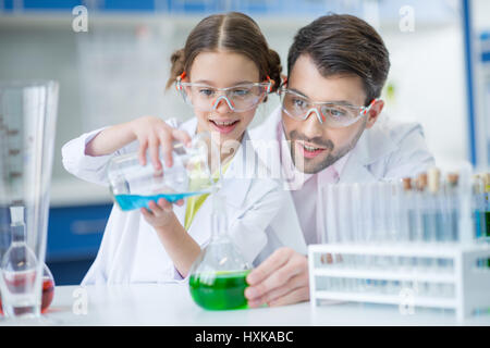 Insegnante e studente di scienziati in occhiali di protezione rendendo esperimento in laboratorio Foto Stock