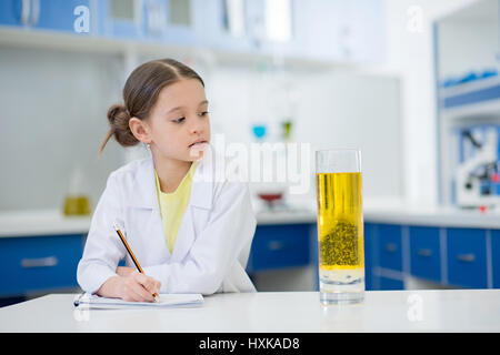 Ritratto di ragazza scienziato a scrivere i risultati di esperimento in laboratorio Foto Stock