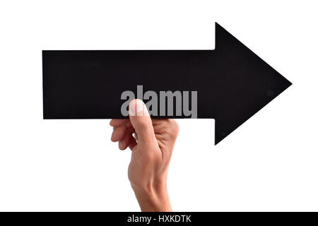 Primo piano di un giovane uomo caucasico tenendo un vuoto nero freccia a forma di cartello rivolto verso destra, contro uno sfondo bianco Foto Stock