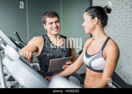 Istruttore personale Tracking clienti progressi in palestra Foto Stock