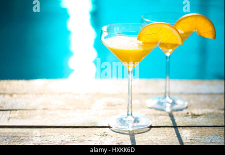 Bicchieri di champagne con fetta di arancia. Cocktail di mimosa. Summer party in piscina Foto Stock
