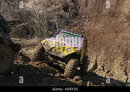 Un off-road auto è seguito un altro a quattro ruote vhicle su una collina fangoso a offroad concorrenza nella cava di ghiaia a Radovljica Slovenia Foto Stock