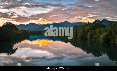 Il tramonto e le nuvole riflettono in un ampio ancora alberata come specchio di fiume, Puerto Princesa, Filippine. Foto Stock