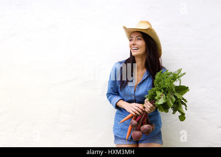 Ritratto di una donna ridere holding mazzetto di verdure in mani Foto Stock