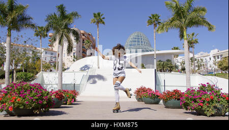 Femmina rollerskates da indossare a cavallo nel parco Foto Stock