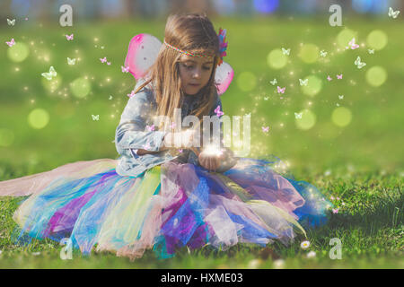 Bellissima bambina con magic butterfly; il concetto di fantasia Foto Stock
