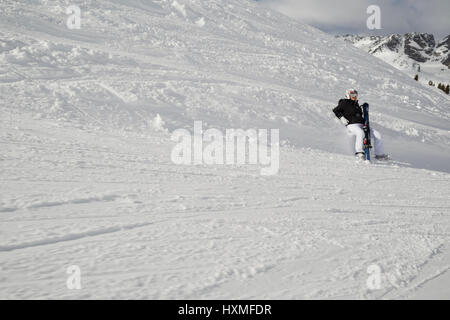 Uno sciatore si rilassa sul lato di un sentiero nel Domaine de Balme ski resort in Le Tour al di fuori di Chamonix-Mont-Blanc. Foto Stock