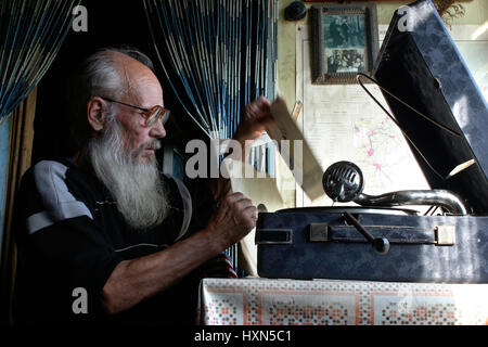Zona di Leningrado di San Pietroburgo, Russia - Agosto 23, 2006: Valentin Stepanovic Shramko nato nel 1938, Graybeard uomo anziano con gli occhiali seduto vicino a o Foto Stock