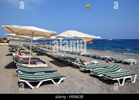 Kemer, Turchia - 29 agosto 2014: sdraio e ombrelloni sulla spiaggia di ghiaia nella zona di villeggiatura di costa di Antalya. Foto Stock